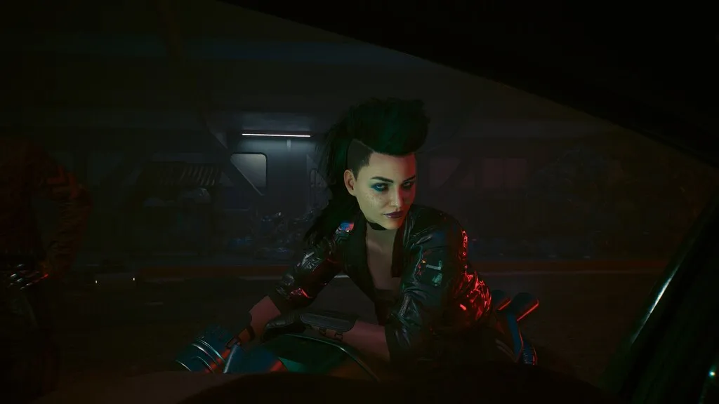 A woman with a mohawk on a bike in a red lit garage